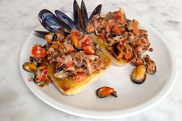Crostoni di cozze, porri e pomodori